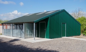 a green kennel block with a green roof